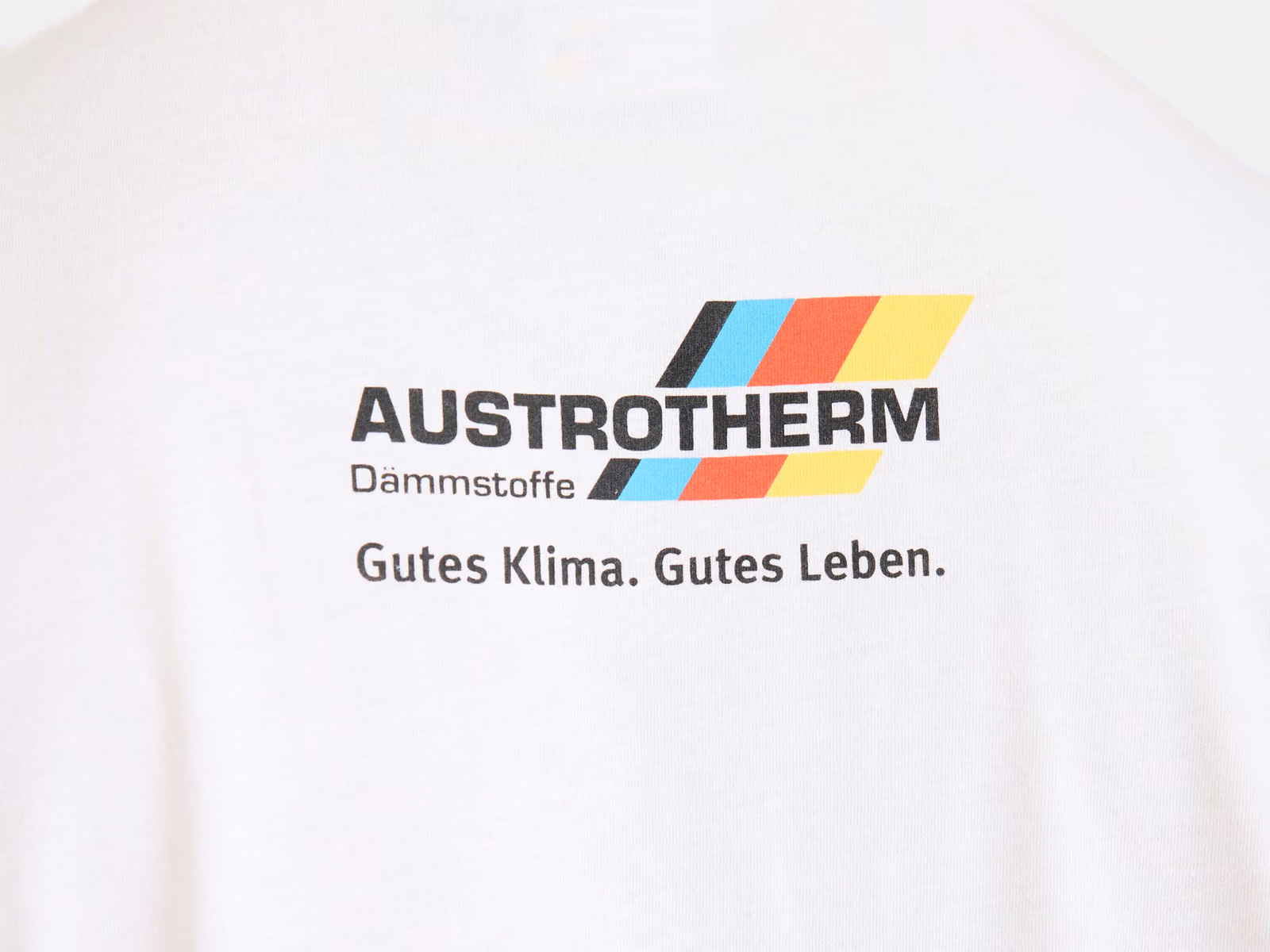Logo og slogan trykt hen over den øverste del af ryggen på en hvid T-shirt