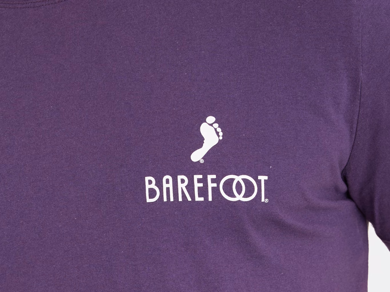 Mittig platzierter Brustdruck auf einem violetten T-Shirt, unterhalb des Halsausschnitts