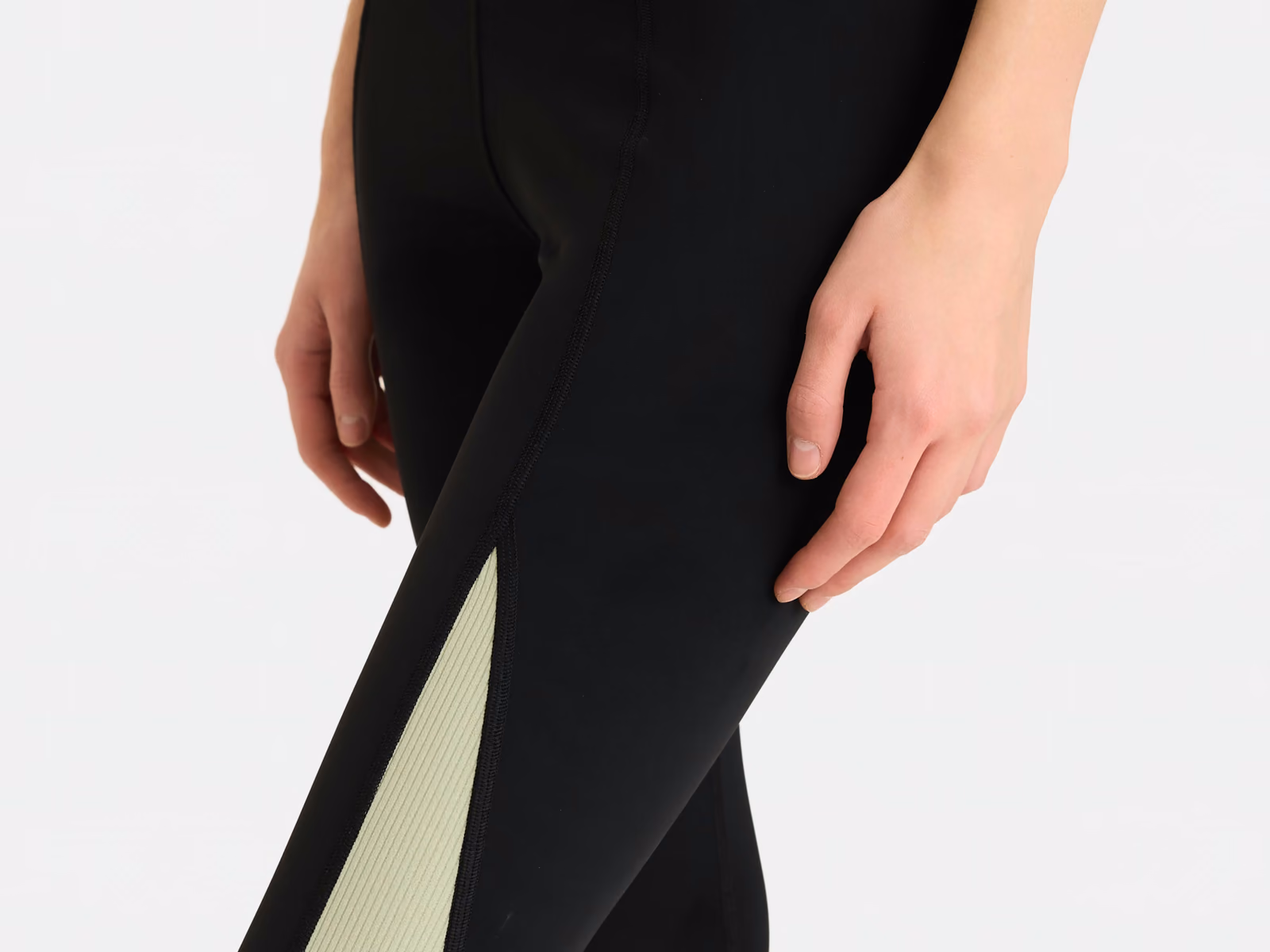 Leggings neri con un pannello a contrasto verde salvia lungo la gamba