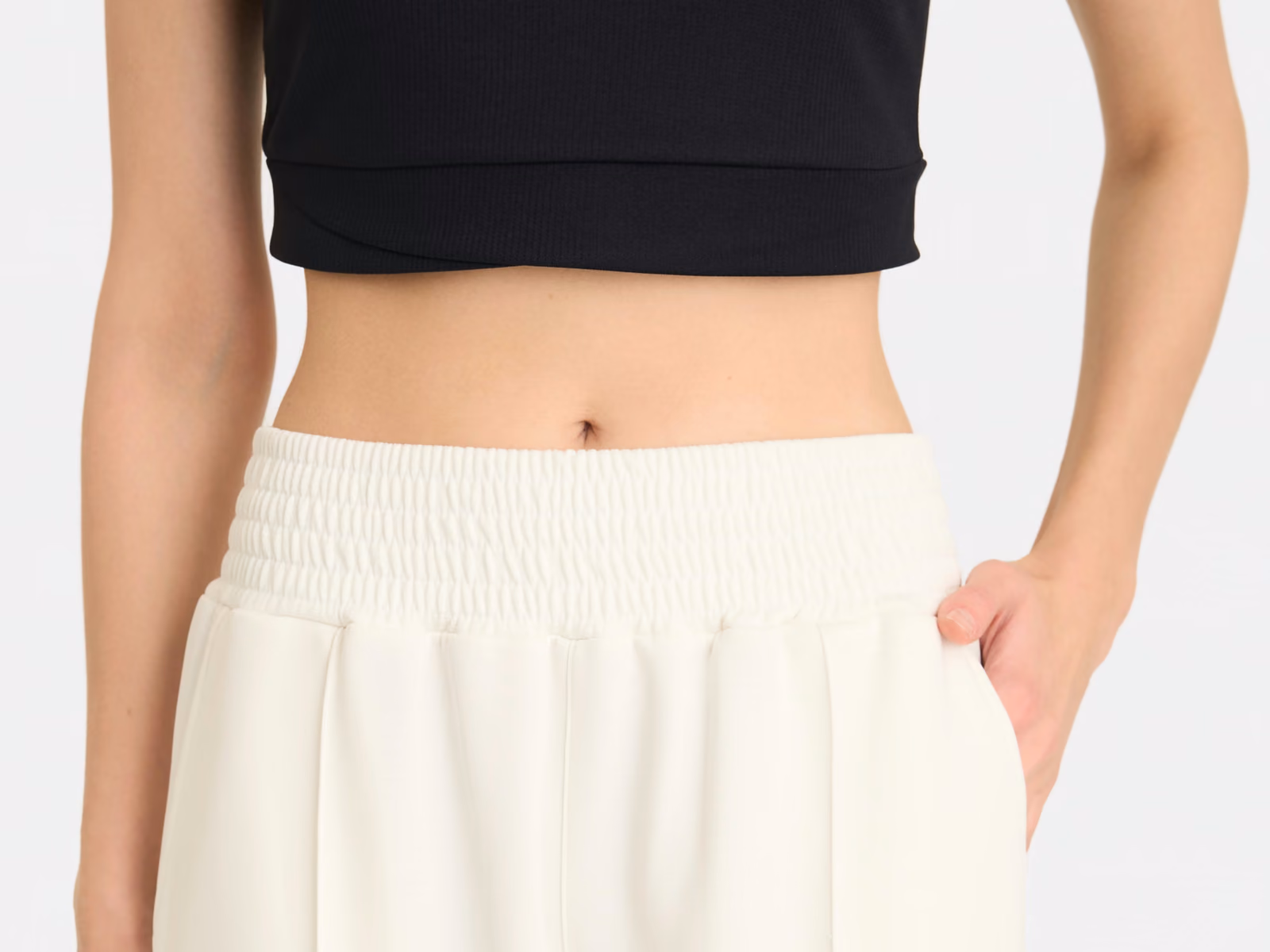 Breiter Gummizugbund an einer cremeweißen Strickhose