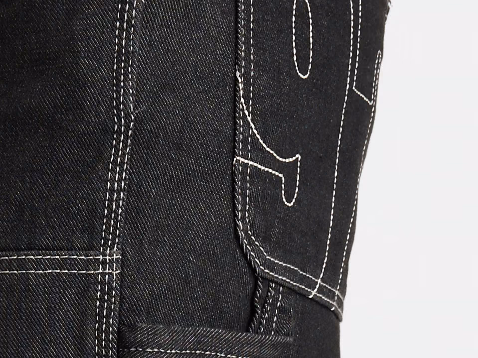 Tasca posteriore di jeans neri con impunture bianche a contrasto