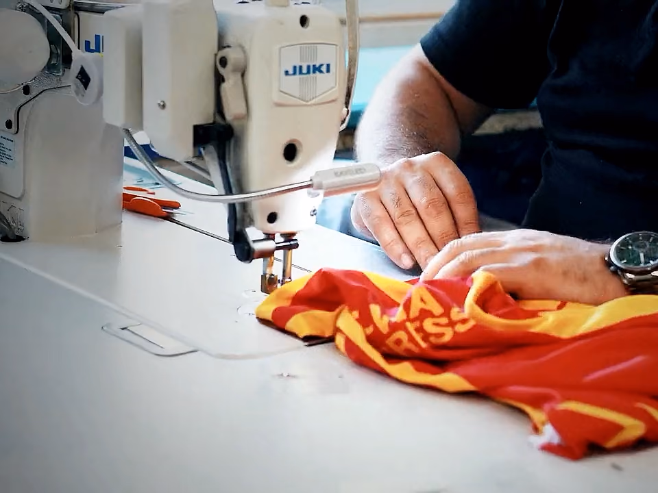 Nähkraft näht ein sublimiertes Trikot an einer Industrienähmaschine