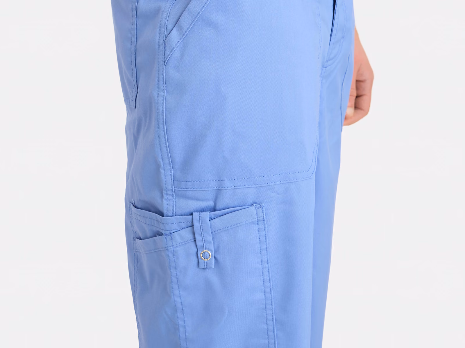 Cargotasche mit Knopflasche am Bein einer hellblauen Schlupfhose