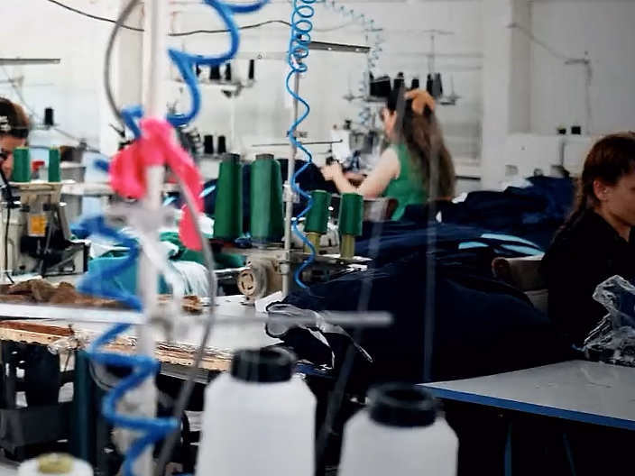 Symaskiner og trådkoner langs en produktionslinje