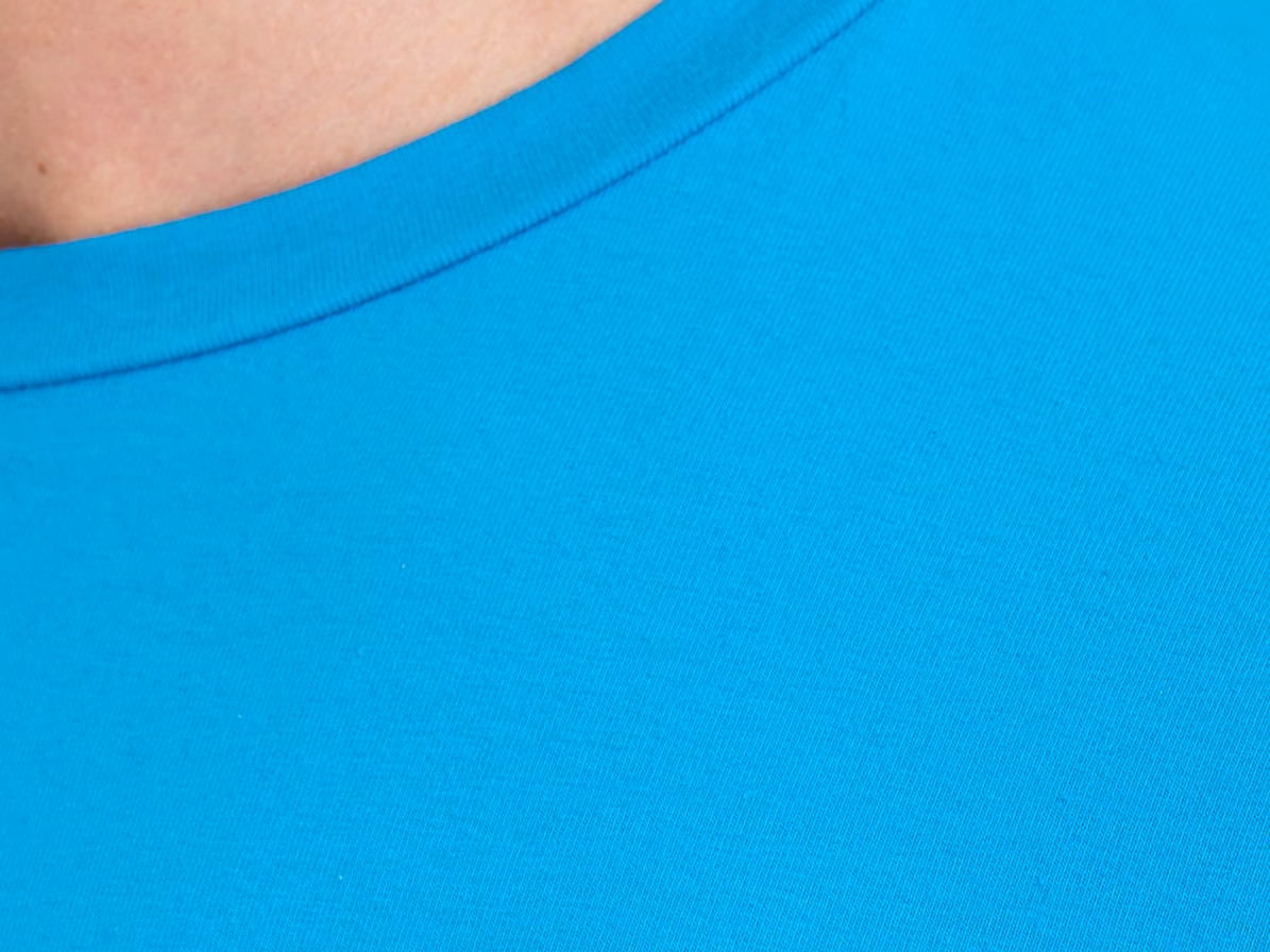 Nærbillede af halsribben på en turkis T-shirt med rund hals