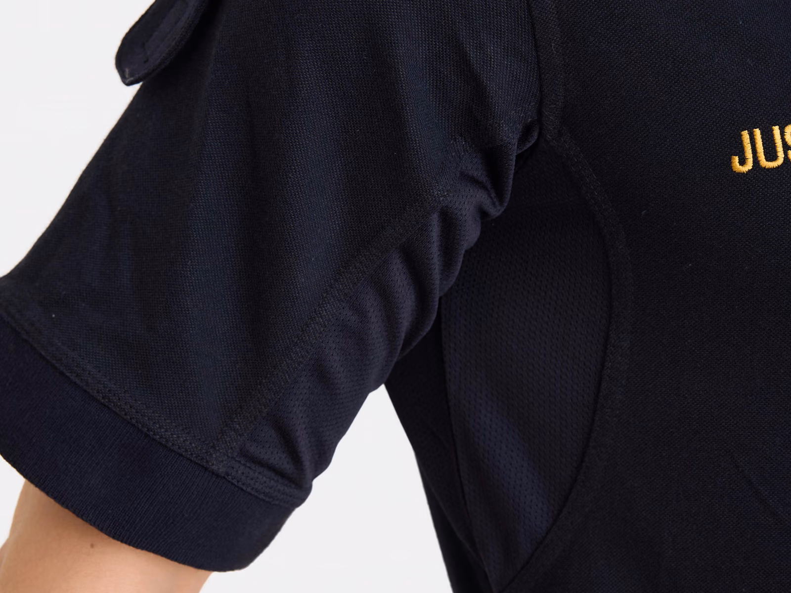 Ærme på en marineblå uniformsskjorte med guldbogstaver over ærmeoplægget
